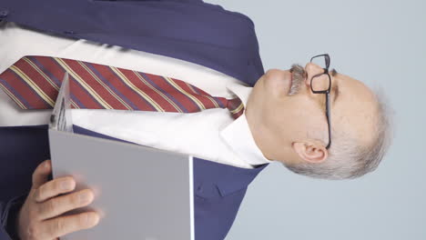 Vertical-video-of-An-angry-old-businessman-angrily-closes-his-laptop.